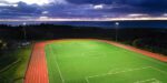 Universite Sainte-Anne lights DarkSky certified soccer field while the sunsets behind mountains in the background.